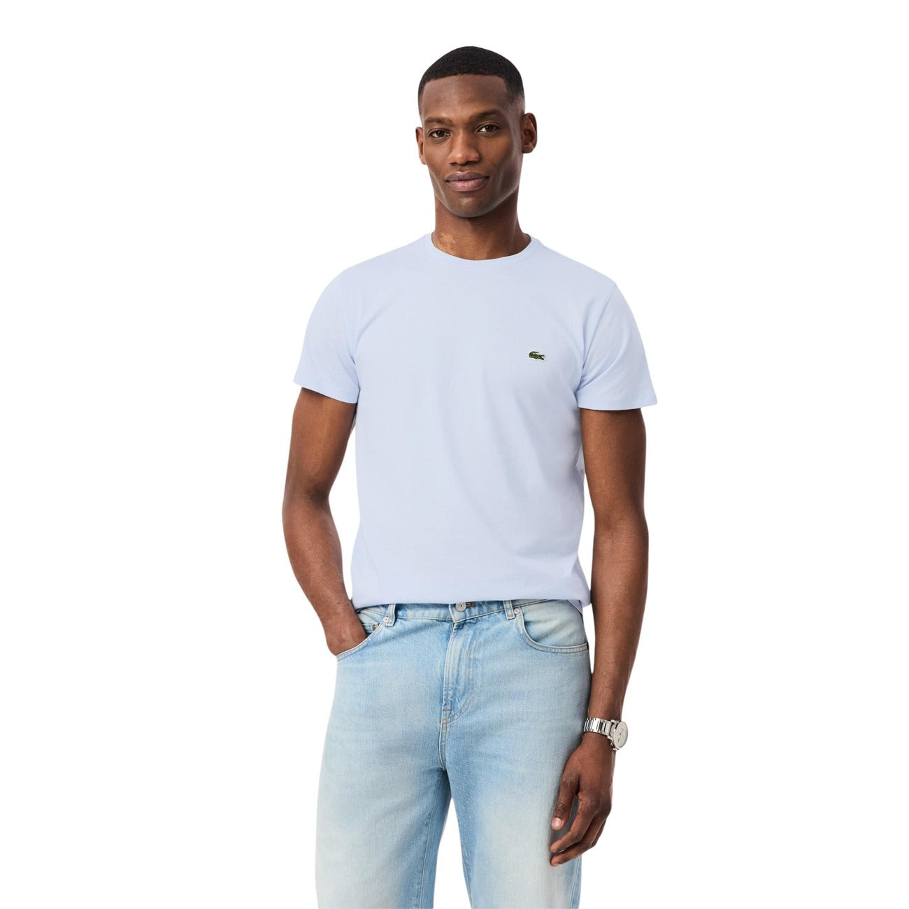 Man wearing a light blue t-shirt and jeans on a white background