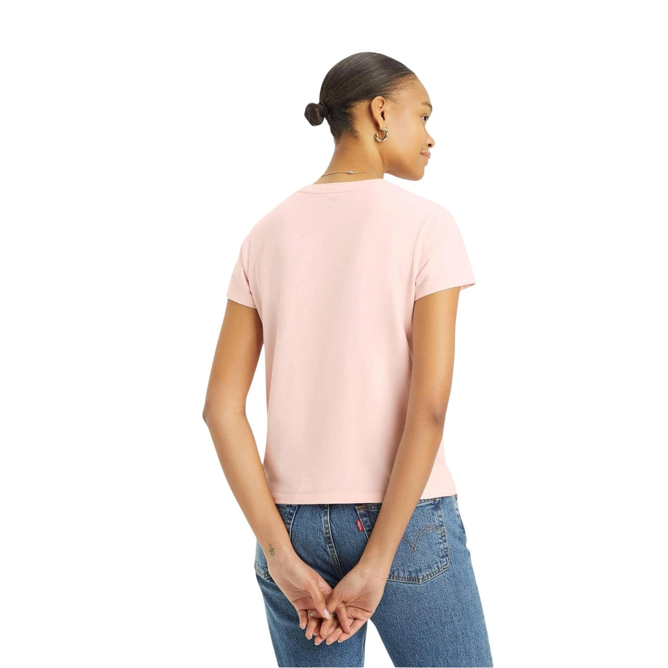 Person wearing a pink t-shirt and blue jeans on a white background