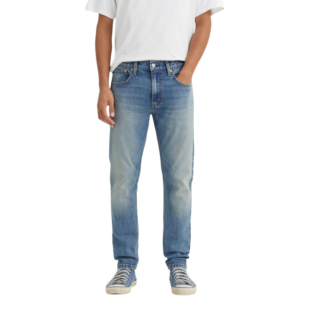 Person wearing light blue jeans and a white t-shirt on a white background